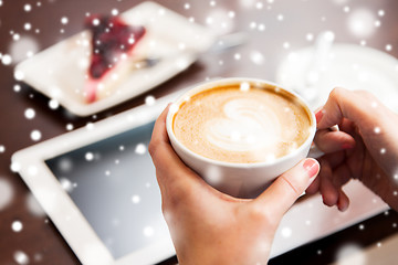 Image showing close up of hands with coffee, tablet pc and cake