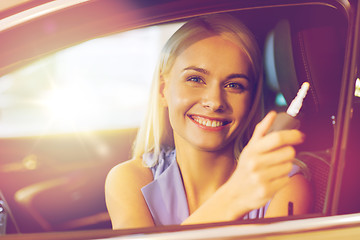 Image showing happy woman getting car key in auto show or salon