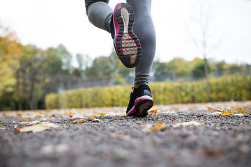 Image showing close up of young woman running in autumn park