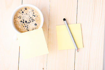 Image showing Wood desk with office supplies and cup of coffee