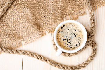 Image showing Cup of coffee with foam on wooden table