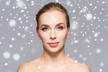 Image showing beautiful woman face over gray background and snow