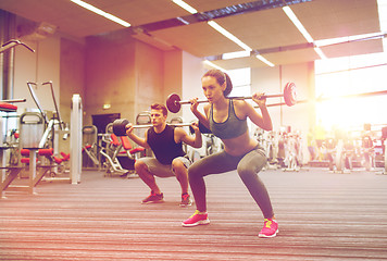 Image showing young man and woman training with barbell in gym