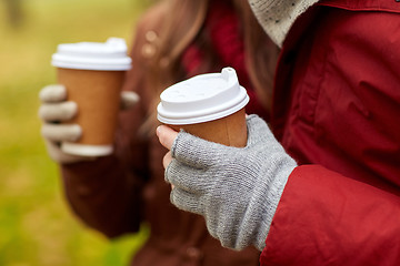 Image showing close up of couple hands with coffee in autumn