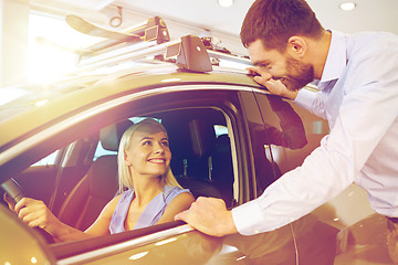 Image showing happy couple buying car in auto show or salon