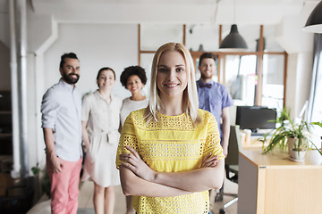 Image showing happy young woman over creative team in office