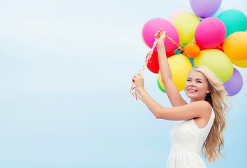 Image showing smiling woman with colorful balloons outside