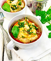 Image showing Fish baked with tomato in white bowl on linen napkin