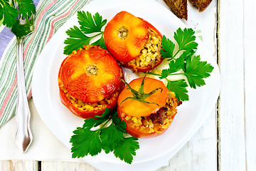 Image showing Tomatoes stuffed with bulgur and parsley in plate on board top