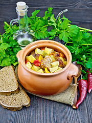 Image showing Roast meat and potatoes in clay pot on board