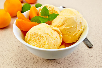 Image showing Ice cream apricot in white bowl on table