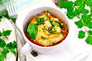 Image showing Fish baked with tomato in white bowl on board