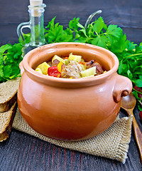 Image showing Roast meat and squash in clay pot on board