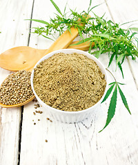 Image showing Flour hemp in bowl with spoon and leaf on board