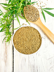 Image showing Flour hemp in bowl with spoon and leaf on board top