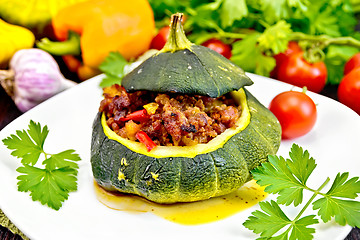 Image showing Squash green stuffed with meat and vegetables on dark board