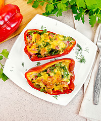 Image showing Pepper stuffed with sausage and cheese in plate on table top