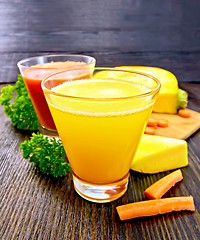 Image showing Juice pumpkin and carrot with parsley on board