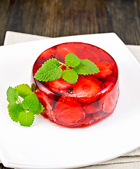 Image showing Jelly strawberry with mint on napkin and dark board