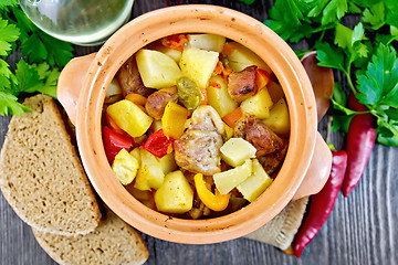 Image showing Roast meat and potatoes in clay pot on board top