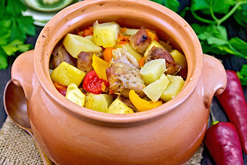 Image showing Roast meat and vegetables in clay pot on burlap