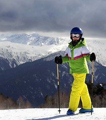 Image showing Young skier with ski poles at sun mountains and cloudy gray sky