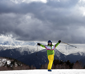 Image showing Happy young skier with ski poles in sun mountains