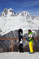 Image showing Young snowboarder with helmet in hands and snowboard on viewpoin