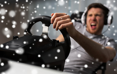Image showing man playing car racing video game with wheel