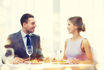 Image showing smiling couple eating main course at restaurant