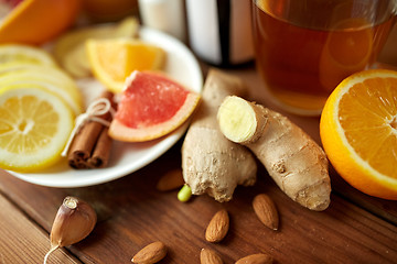 Image showing ginger, citrus fruits, tea or honey on wood