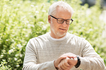 Image showing senior man checking time on his wristwatch