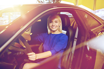 Image showing happy woman inside car in auto show or salon