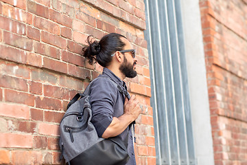 Image showing man with backpack standing at city street wall