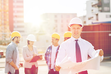 Image showing group of builders with tablet pc and blueprint