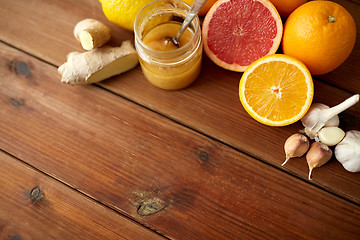 Image showing honey, citrus fruits, ginger and garlic on wood