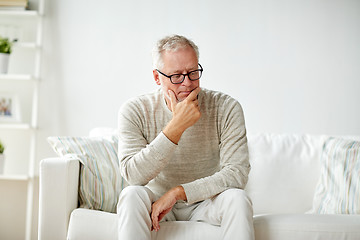 Image showing  senior man sitting on sofa at home and thinking