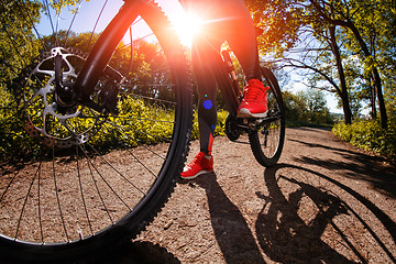 Image showing Young woman having fun riding a bicycle in the park.