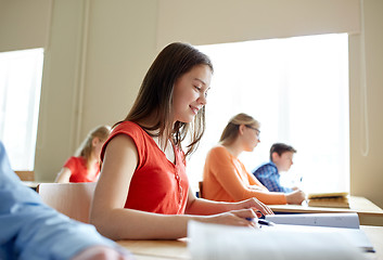 Image showing happy student girl with book writing school test