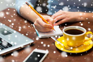 Image showing woman writing to notebook with pencil at office