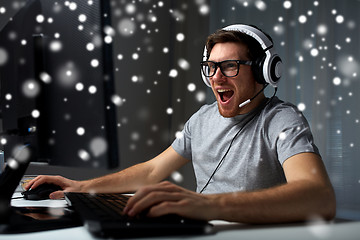 Image showing man in headset playing computer video game at home