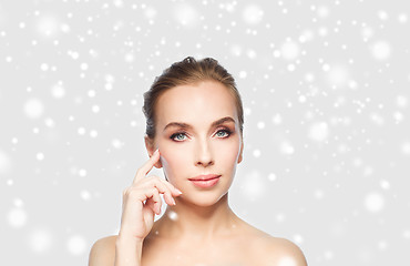 Image showing beautiful woman showing her cheekbone over snow