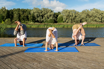 Image showing people making yoga in crane pose outdoors