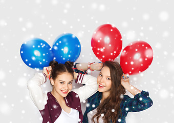 Image showing happy teenage girls with helium balloons over snow