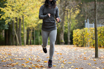 Image showing close up of young woman running in autumn park