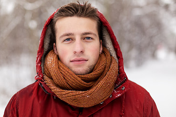 Image showing happy man in winter jacket with hood outdoors