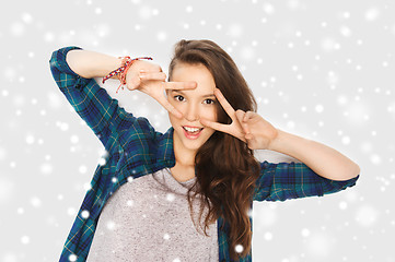 Image showing happy smiling teenage girl showing peace sign