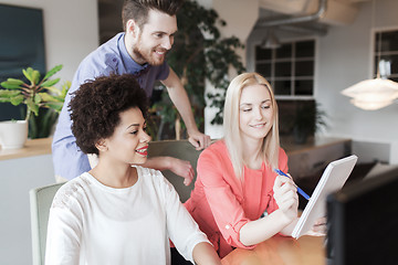 Image showing happy creative team with computer in office