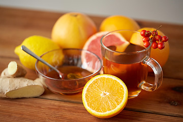 Image showing tea with honey, lemon and ginger on wood