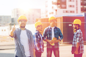 Image showing group of smiling builders in hardhats outdoors